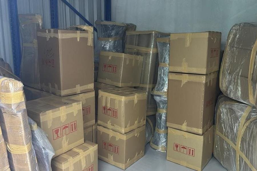 Packed cardboard boxes and protected furniture in storage